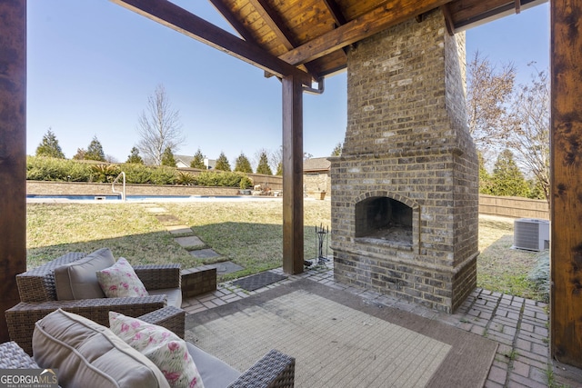 view of patio / terrace with a fenced in pool, fence, an outdoor living space with a fireplace, and central AC unit