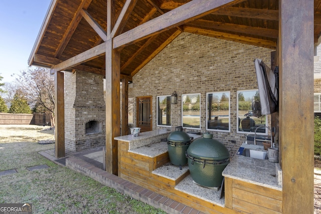 view of patio with an outdoor brick fireplace, a sink, and area for grilling