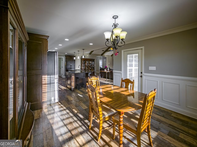 dining room featuring a chandelier, a decorative wall, recessed lighting, dark wood-type flooring, and ornamental molding