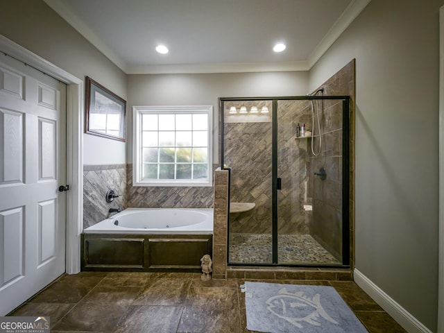 bathroom with ornamental molding, a garden tub, a shower stall, and baseboards