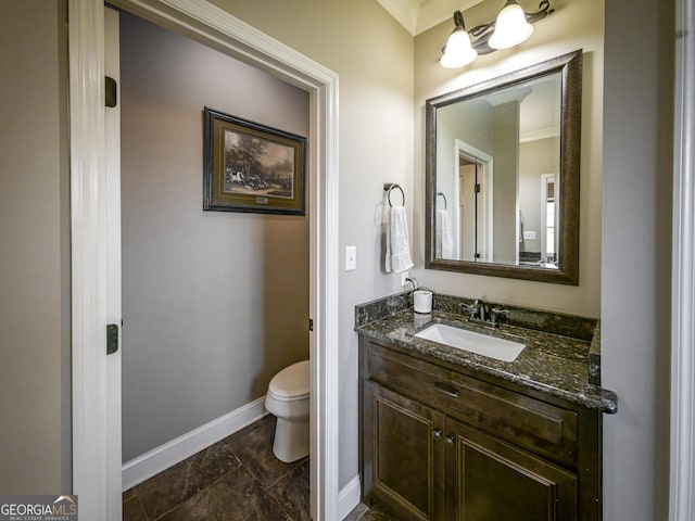 bathroom featuring baseboards, vanity, and toilet