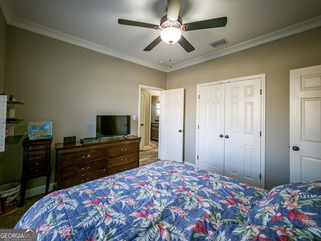 bedroom featuring ceiling fan, carpet floors, visible vents, a closet, and crown molding