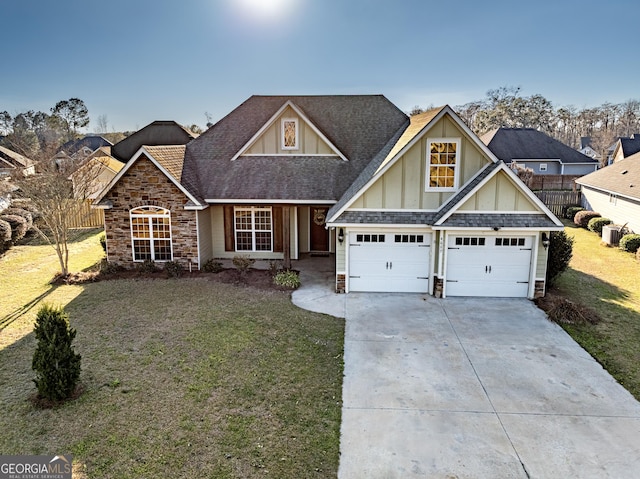 craftsman house with stone siding, roof with shingles, concrete driveway, and a front yard