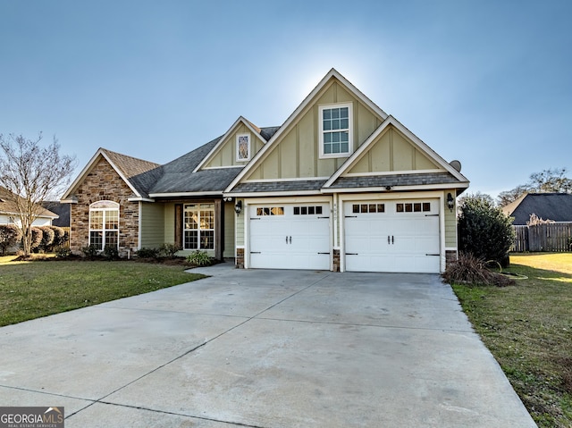 craftsman-style house featuring stone siding, concrete driveway, board and batten siding, and a front yard