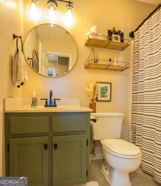 bathroom featuring toilet, a shower with shower curtain, tile patterned flooring, and vanity