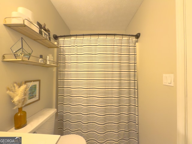 bathroom with a shower with shower curtain, a textured ceiling, toilet, and vanity