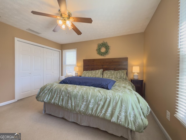 bedroom featuring carpet floors, a ceiling fan, visible vents, baseboards, and a closet