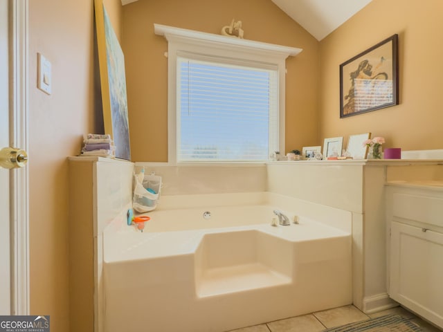 full bath featuring lofted ceiling, vanity, a bath, and tile patterned floors