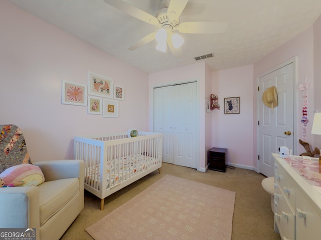 bedroom with a closet, visible vents, light carpet, ceiling fan, and baseboards