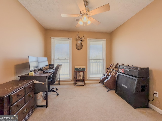 office space with a ceiling fan, a wealth of natural light, light colored carpet, and baseboards