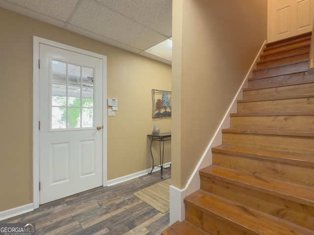 entryway with a paneled ceiling, stairs, baseboards, and wood finished floors