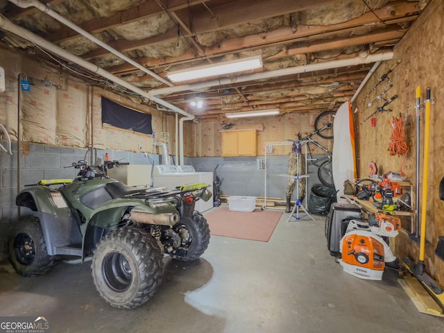 basement with a garage and washing machine and clothes dryer