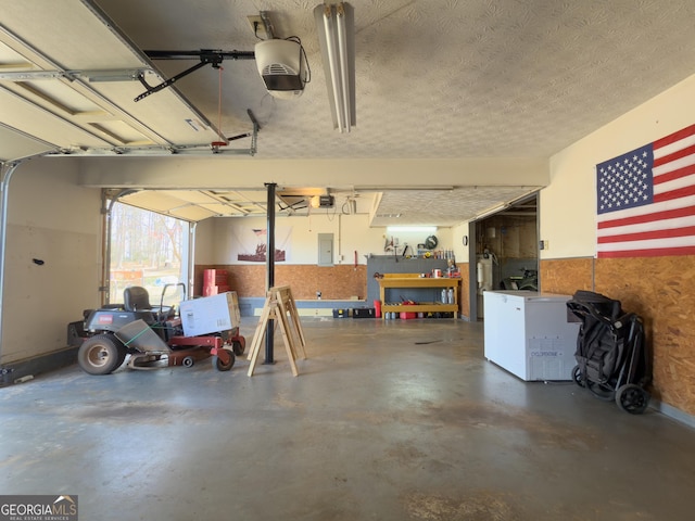 garage with a workshop area, electric panel, and a garage door opener