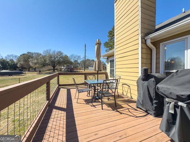 deck featuring a grill and outdoor dining area