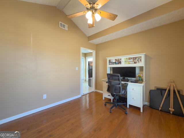 office space featuring lofted ceiling, ceiling fan, hardwood / wood-style flooring, visible vents, and baseboards