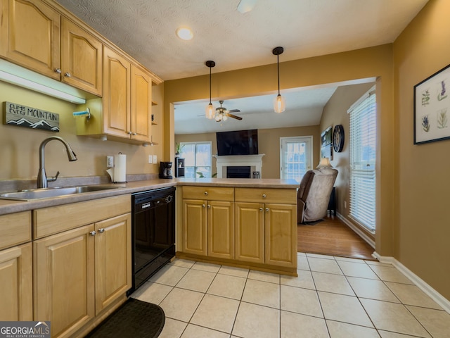 kitchen with light tile patterned flooring, a peninsula, a fireplace, a sink, and dishwasher