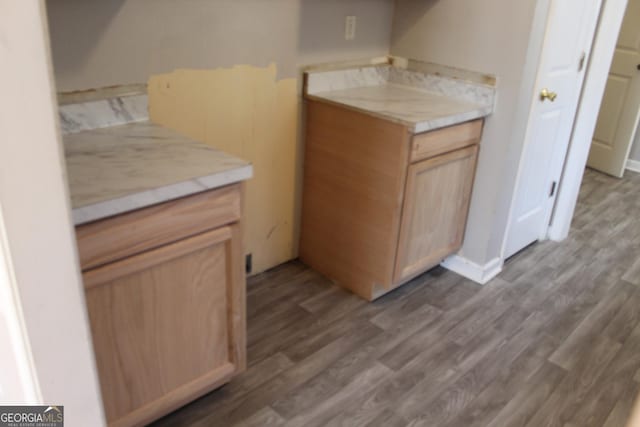 kitchen featuring light brown cabinets, dark wood finished floors, and light countertops