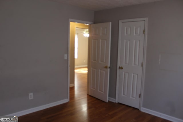 unfurnished bedroom with wood finished floors and baseboards