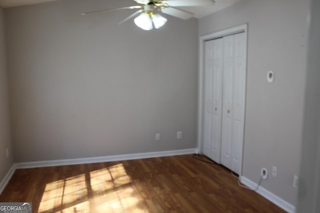 unfurnished bedroom featuring a closet, ceiling fan, baseboards, and wood finished floors