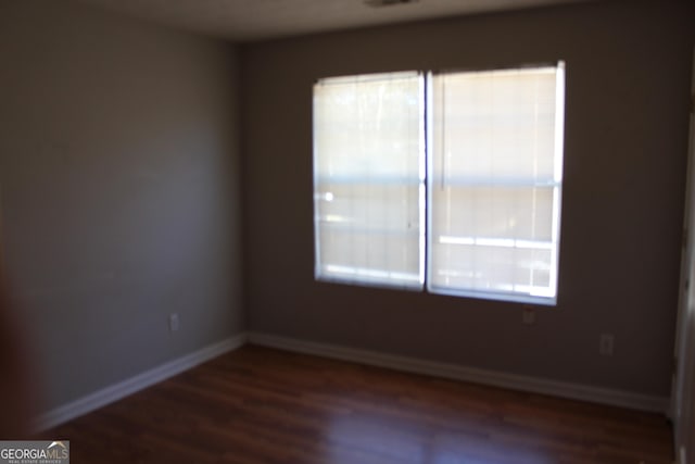 unfurnished room with wood finished floors and baseboards