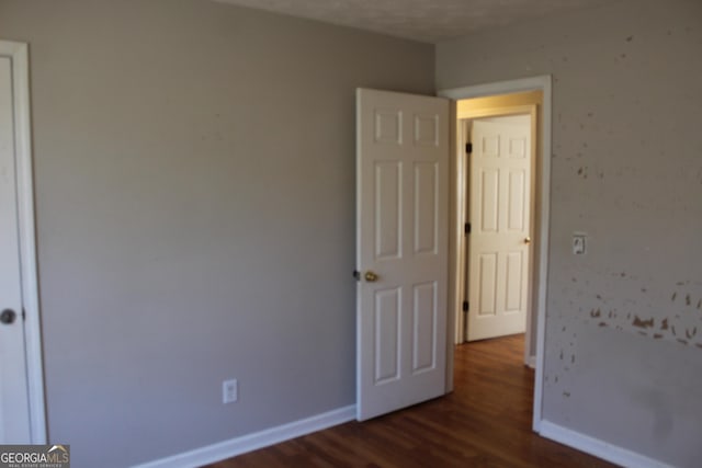 unfurnished bedroom featuring dark wood-style floors and baseboards