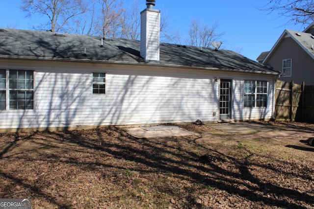 back of property featuring fence and a chimney