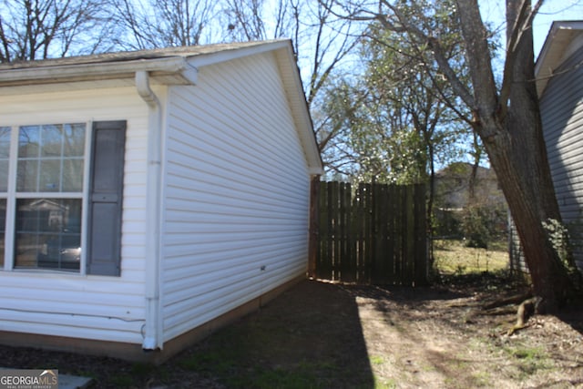 view of side of property with fence and an outdoor structure