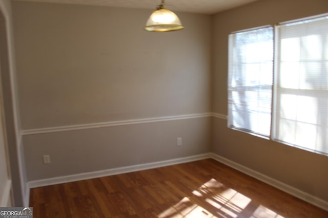 unfurnished room featuring baseboards and wood finished floors