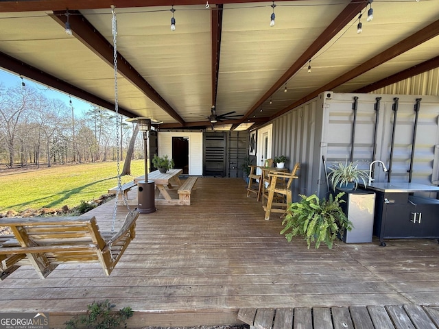 wooden deck featuring a yard and a ceiling fan