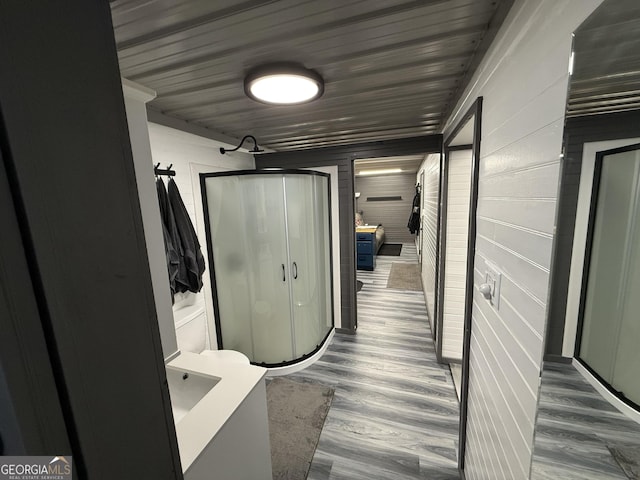 bathroom featuring wooden ceiling, a stall shower, and wood finished floors