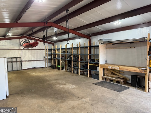 garage with freestanding refrigerator and a workshop area