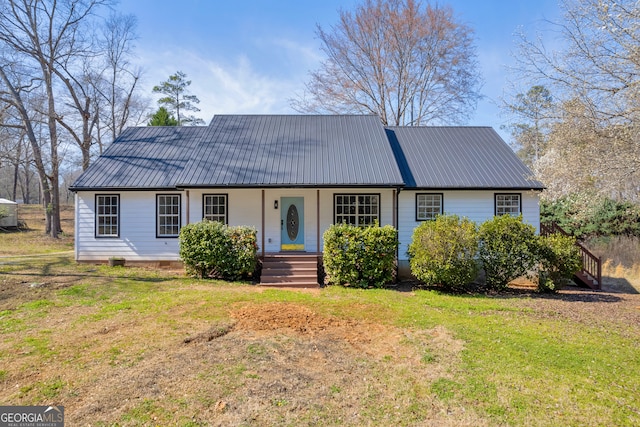 view of front of home featuring crawl space, metal roof, a front lawn, and covered porch