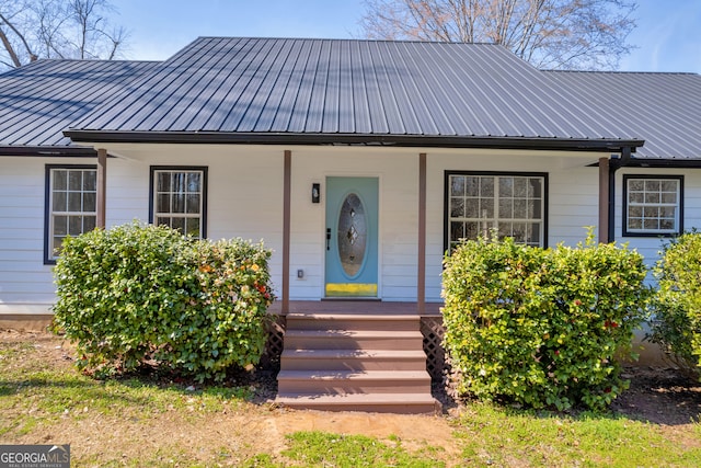 bungalow featuring covered porch, metal roof, and a standing seam roof