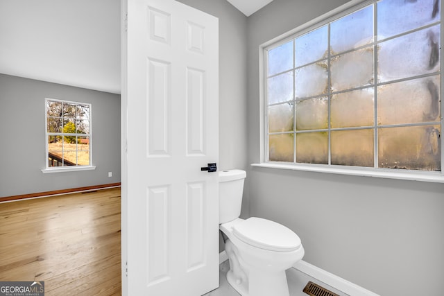 bathroom featuring visible vents, wood finished floors, toilet, and baseboards