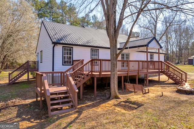 back of house with a deck, metal roof, an outdoor fire pit, and stairway