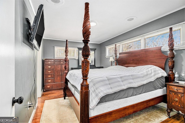 bedroom with light wood-type flooring and crown molding