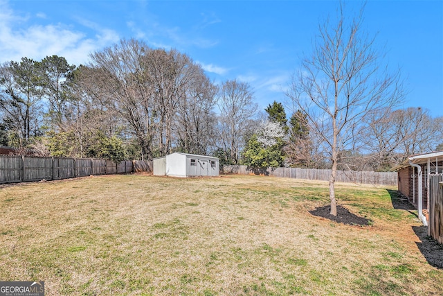 view of yard with a fenced backyard, a storage unit, and an outbuilding