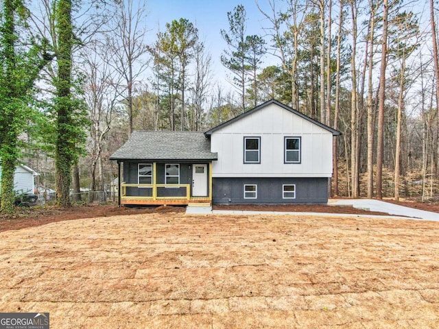 split level home featuring roof with shingles and board and batten siding