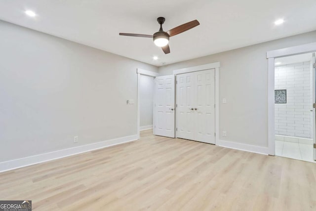 unfurnished bedroom featuring light wood finished floors, ensuite bath, and baseboards