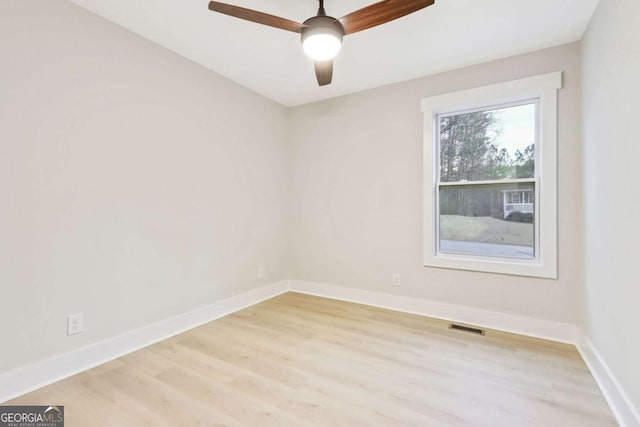 empty room with ceiling fan, light wood-type flooring, visible vents, and baseboards