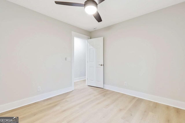 empty room featuring ceiling fan, light wood-type flooring, and baseboards