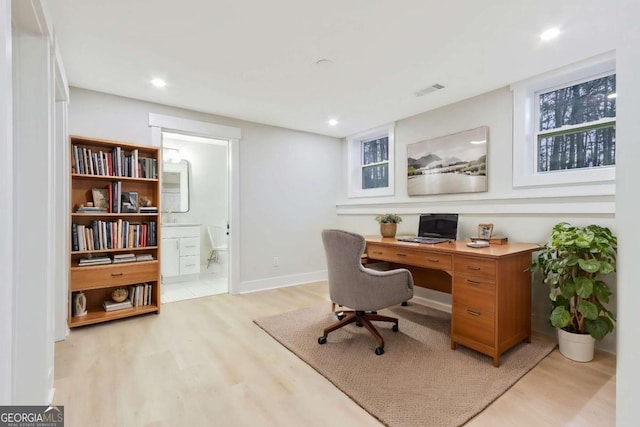 office space with baseboards, light wood finished floors, visible vents, and recessed lighting