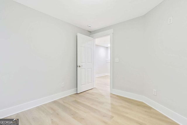 spare room with light wood-type flooring and baseboards