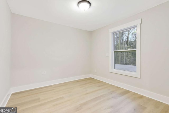 spare room with light wood-style floors and baseboards