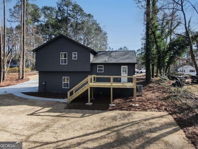 back of house with driveway, stairway, a wooden deck, and central air condition unit