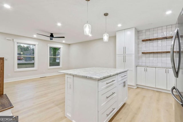 kitchen with light wood-type flooring, freestanding refrigerator, white cabinets, and open shelves