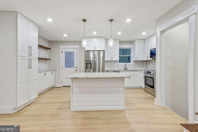 kitchen with light wood-style flooring, a kitchen island, stainless steel appliances, white cabinetry, and open shelves