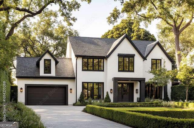 view of front of home featuring a garage, decorative driveway, and stucco siding