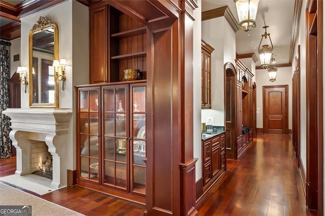 corridor with ornamental molding and dark wood-style floors