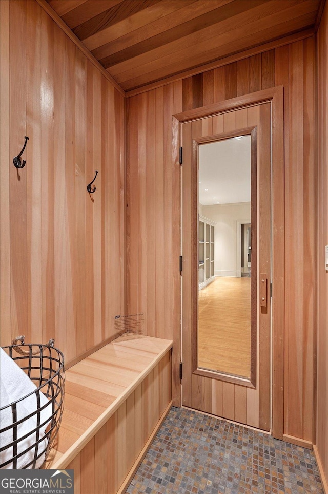 mudroom featuring wood ceiling and wood walls